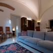 Divano in velluto grigio con sedie nel salotto - VeronaJourneys