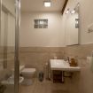 Ampio bagno in marmo beige con box doccia - VeronaJourneys