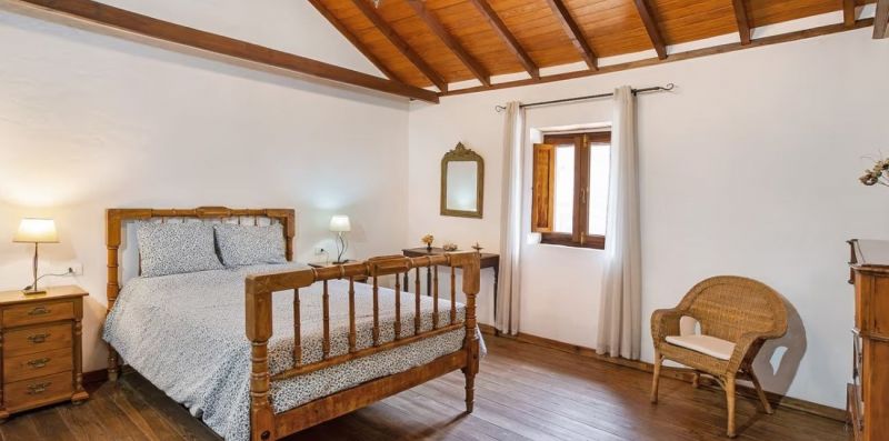 Dormitorio con techo de madera